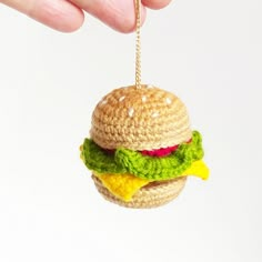 a crocheted hamburger ornament hanging from a chain