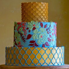 a three tiered cake with blue and yellow frosting