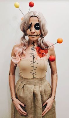 a woman with long blonde hair and makeup is wearing a skeleton costume while standing in front of a white wall