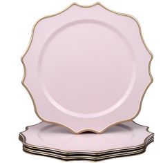 pink and gold dinner plates stacked on top of each other in front of a white background