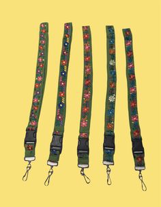 three green lanyards with flowers on them