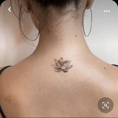 the back of a woman's neck with a lotus tattoo on it