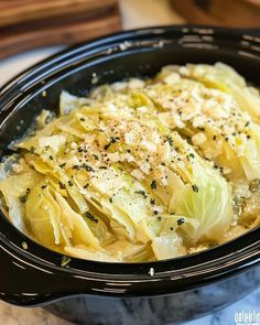 an image of cabbage in a crock pot with parmesan cheese on top