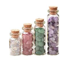 five glass bottles filled with different colored rocks