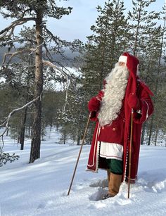 a man dressed as santa claus walking through the snow