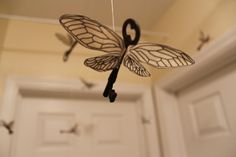 a wind chime hanging from the ceiling in front of a door with birds flying around