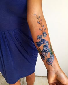 a woman's arm with blue flowers on it