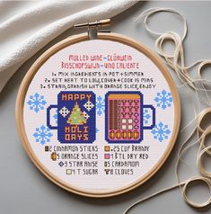 a cross stitch pattern with two mugs on it and some scissors next to it