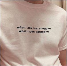 a person wearing a t - shirt that says what i ask for snuggles, what i get struggles