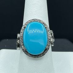 This Is A Beautiful Natural Turquoise And Diamond Ring Set In Sterling Silver. This Ring Features A Beautiful Turquoise That Measures 11.31 Carats In Size As Well As 0.63 Carats Of Diamonds. The Ring Weighs 7.1 Grams And The Deck Of The Ring Measures 17.80 X 16 Mm. This Turquoise Originated In Arizona And The Ring Is Size 8.5. Turquoise Promotes Self-Realisation And Assists Creative Problem Solving. It Is A Symbol Of Friendship, And Stimulates Romantic Love. Turquoise Is The Gemstone Associated With December. This Ring Is Handmade And One Of A Kind. Luxury Turquoise Cabochon Ring, Luxury Blue Turquoise Ring For Formal Occasions, Formal Turquoise Rings With Gemstone Accents, Turquoise Blue Diamond Ring With Center Stone, Formal Turquoise Multi-stone Rings, Formal Fine Jewelry Turquoise Ring With Accent Stones, Oval Diamond Turquoise Ring For Formal Occasions, Formal Oval Turquoise Ring With Diamond, Elegant Blue Turquoise Cabochon Ring