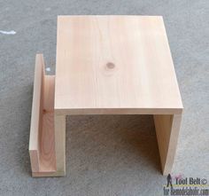 a small wooden table sitting on top of a carpeted floor next to a wall