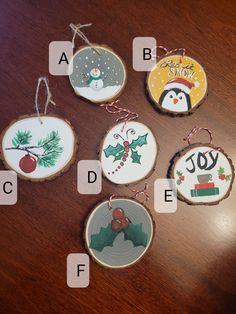 christmas ornaments are hanging on wood slices with words and pictures in the center, along with an ornament that says joy