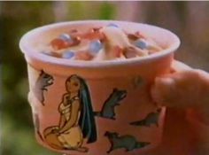 a hand holding a cup with cereal in it and an image of the character winnie pooh