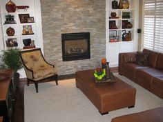 a living room filled with furniture and a fire place in the center of the room