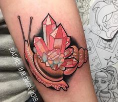 a colorful snail tattoo on the arm with needles and crystals in it's shell