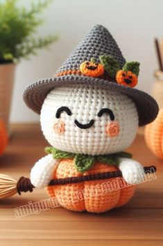 a small crocheted doll with a hat and pumpkin on it's head