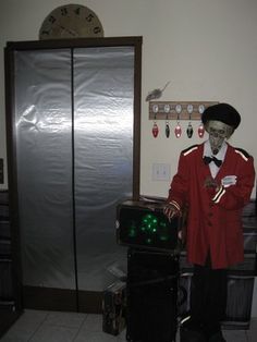 a man in a red jacket and hat standing next to a green light projector