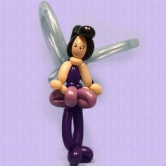 a small figurine is holding a balloon in the shape of a woman's body