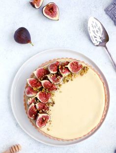 a white plate topped with a cheesecake covered in figs