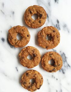 six cookies with chocolate chips arranged on a marble counter top, ready to be eaten