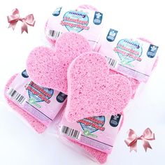 three pink sponge oven mitts with bows on the top and one in the middle