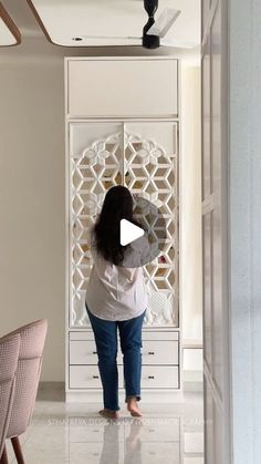 a woman standing in front of a white cabinet