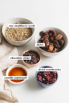 four bowls filled with different types of food on top of a white table next to a napkin