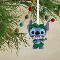 a christmas ornament hanging from a pine tree with the character stitching on it