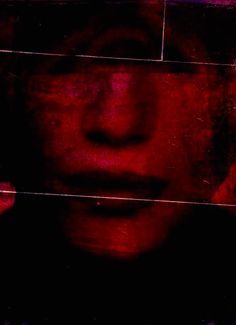 a woman's face is reflected in a red and black mirror with the reflection of her head