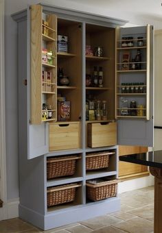 an open pantry door in the middle of a kitchen with shelves full of food and condiments