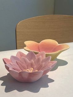 two flower shaped bowls sitting on top of a table