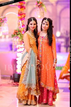 two women standing next to each other in dresses