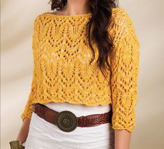 a woman wearing a yellow crochet sweater with a brown belt around her waist