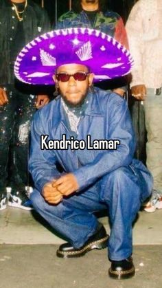 a man sitting on the ground with a purple frisbee over his head and people behind him