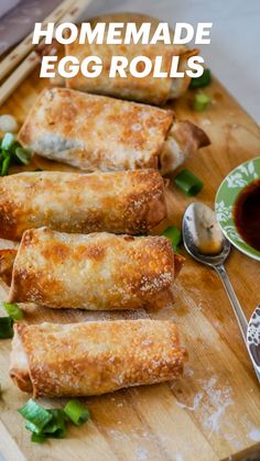 homemade egg rolls on a cutting board with dipping sauce