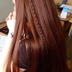 a woman with long red hair sitting at a desk