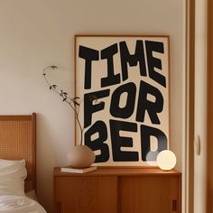 a bed room with a large poster on the wall and a lamp next to it