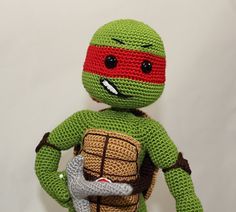 a crocheted teenage mutant holding a knife and wearing a tmnt costume