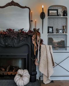 a living room with a fire place, mirror and candles on the fireplace mantel