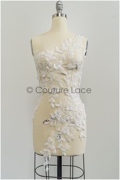 a mannequin with white flowers on it's torso and back, in front of