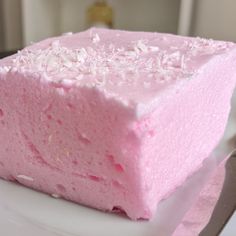 a pink cake sitting on top of a white plate