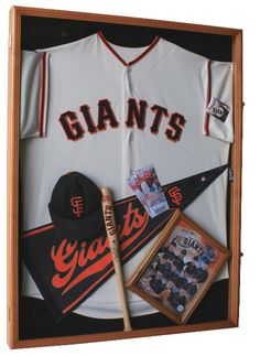 a baseball uniform and bat are in a shadow box with other items on the wall