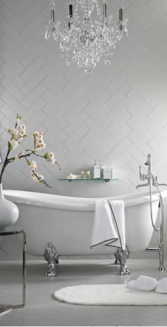 a white bath tub sitting under a chandelier