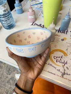 a person holding up a bowl on top of a table