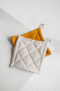 two orange and white pieces of cloth sitting on top of each other next to one another