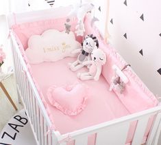 a pink baby crib with stuffed animals in it