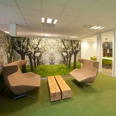 an office with two chairs and a bench in front of a wall mural that has trees on it