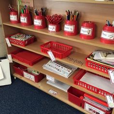 red bins and baskets are on the shelf in this classroom organization unit for students