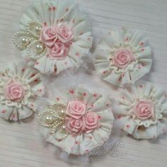 four pink roses and pearls on white fabric