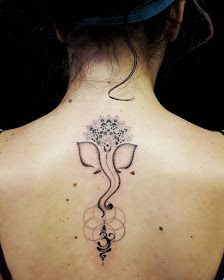 the back of a woman's neck with an elephant tattoo on it